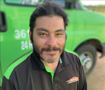 male Project Manager in front of green truck